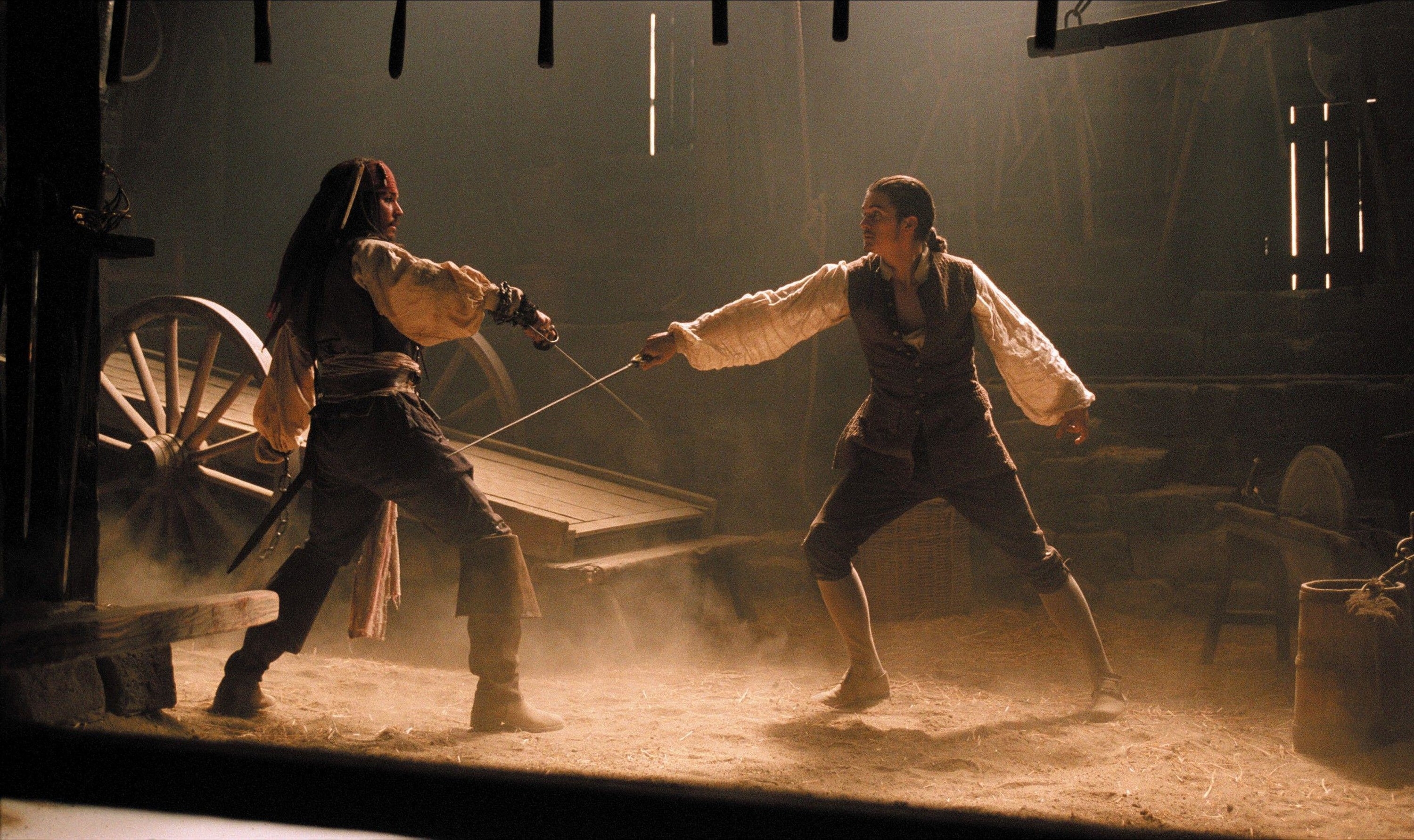 Two pirates have a swordfight in an old barn