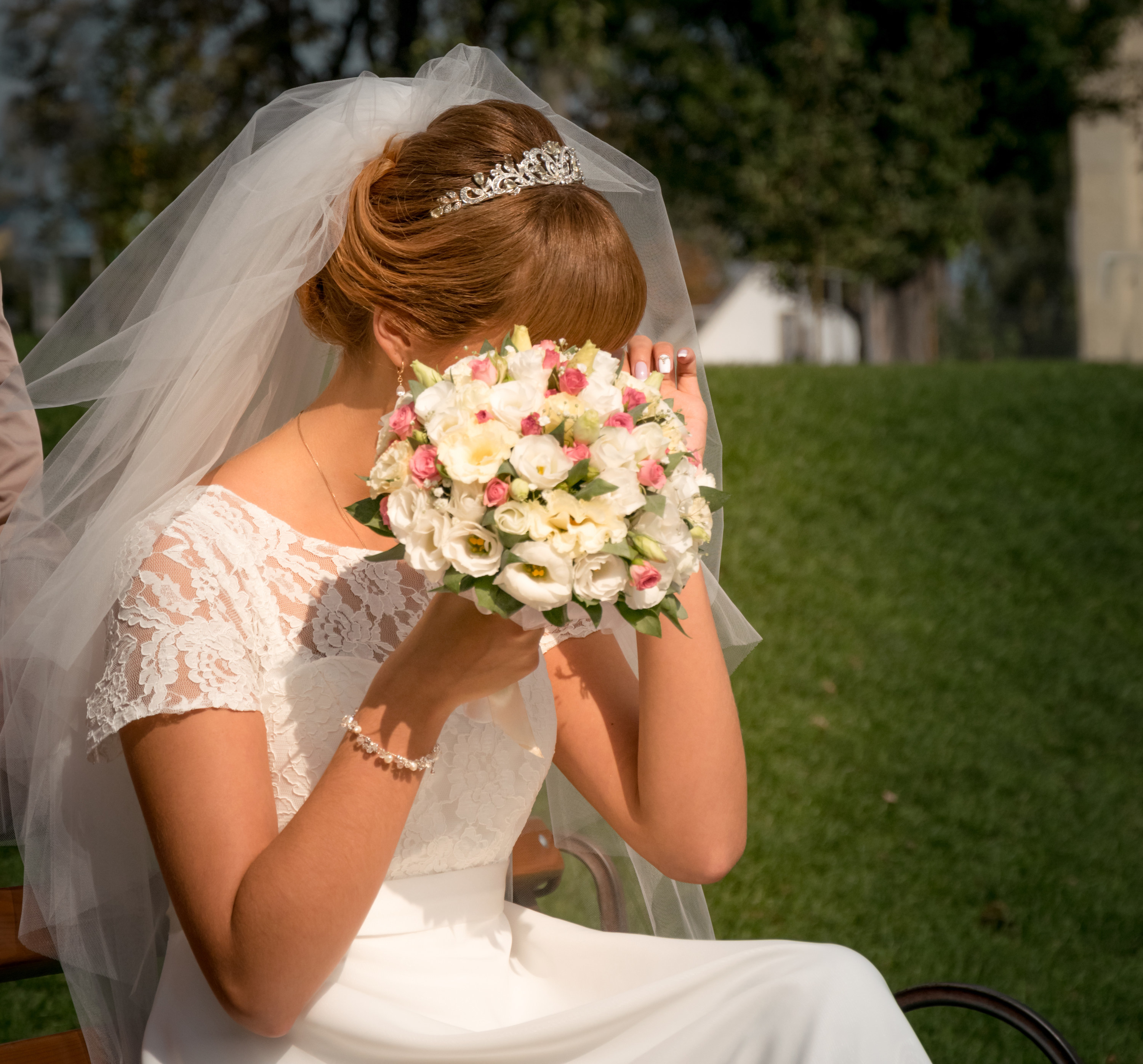 bride crying with a bouquet hiding her face