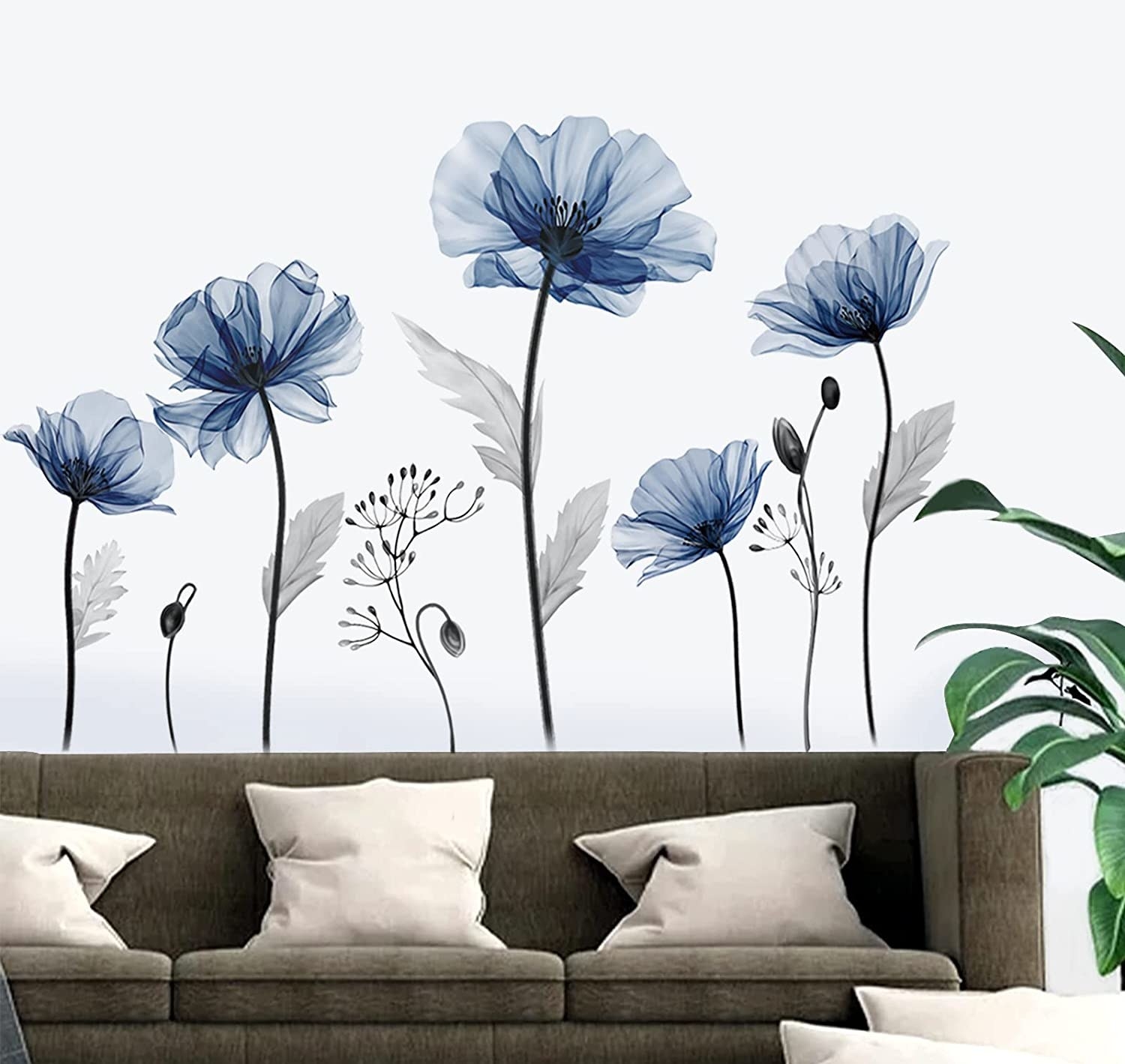 A couch with large floral wall decals behind it