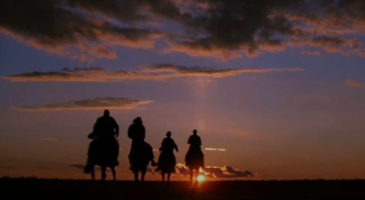 Indiana Jones, Marcus, Sallah and Henry ride their horses toward the sunset