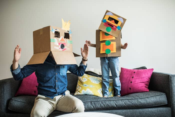 A man and their child dressed in cardboard box costumes