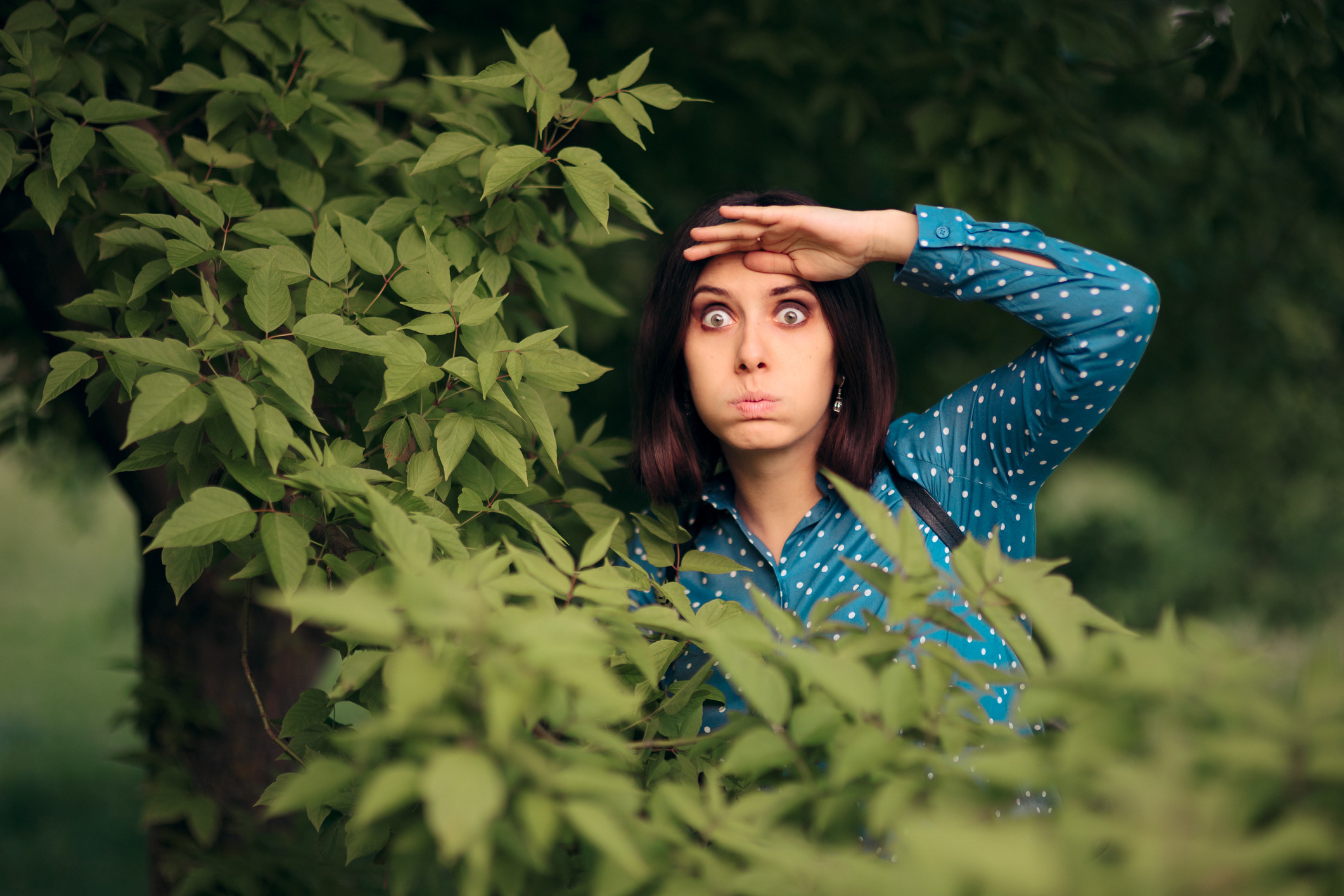 person in the bushes looking for someone