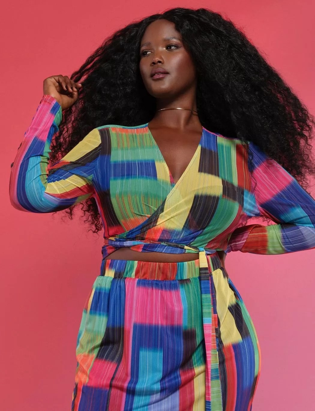 Model wearing multicolored long sleeve mesh wrap top with matching skirt