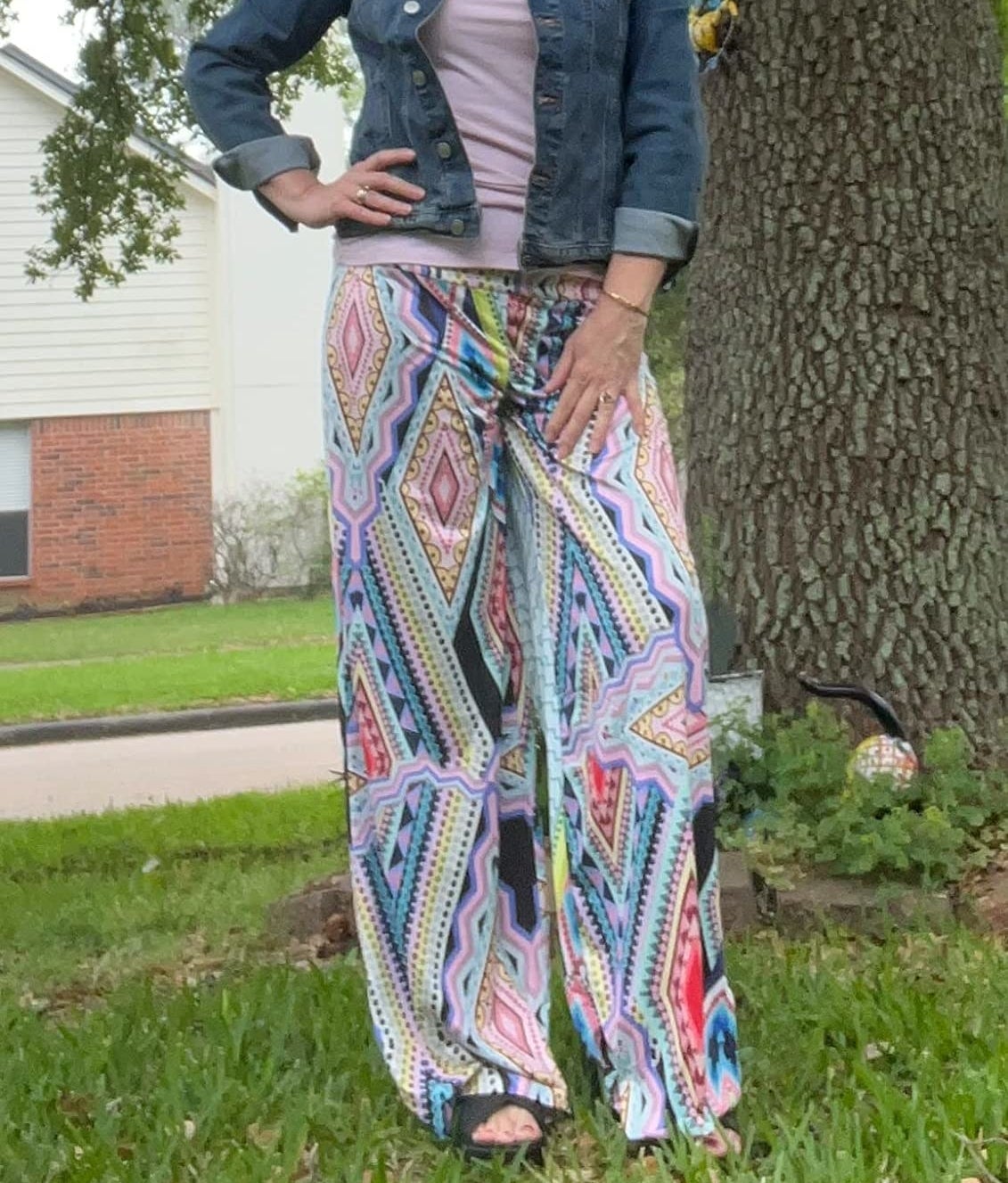 Reviewer wearing geometric pattern multicolor palazzo pants with purple shirt and denim jacket