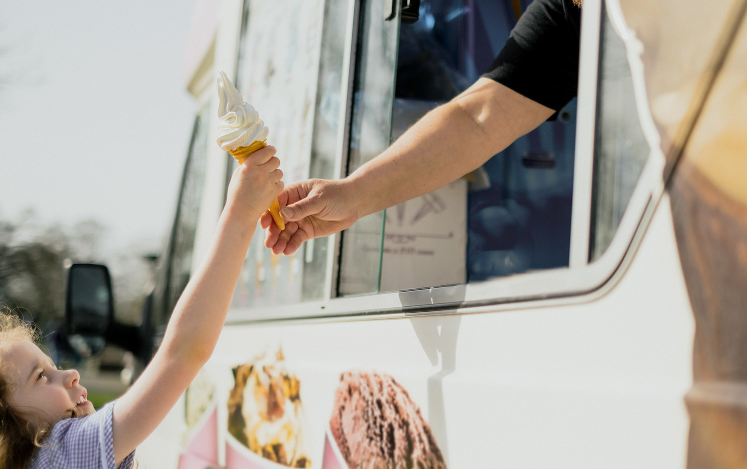 A kid getting an ice cream from the ice cream truck