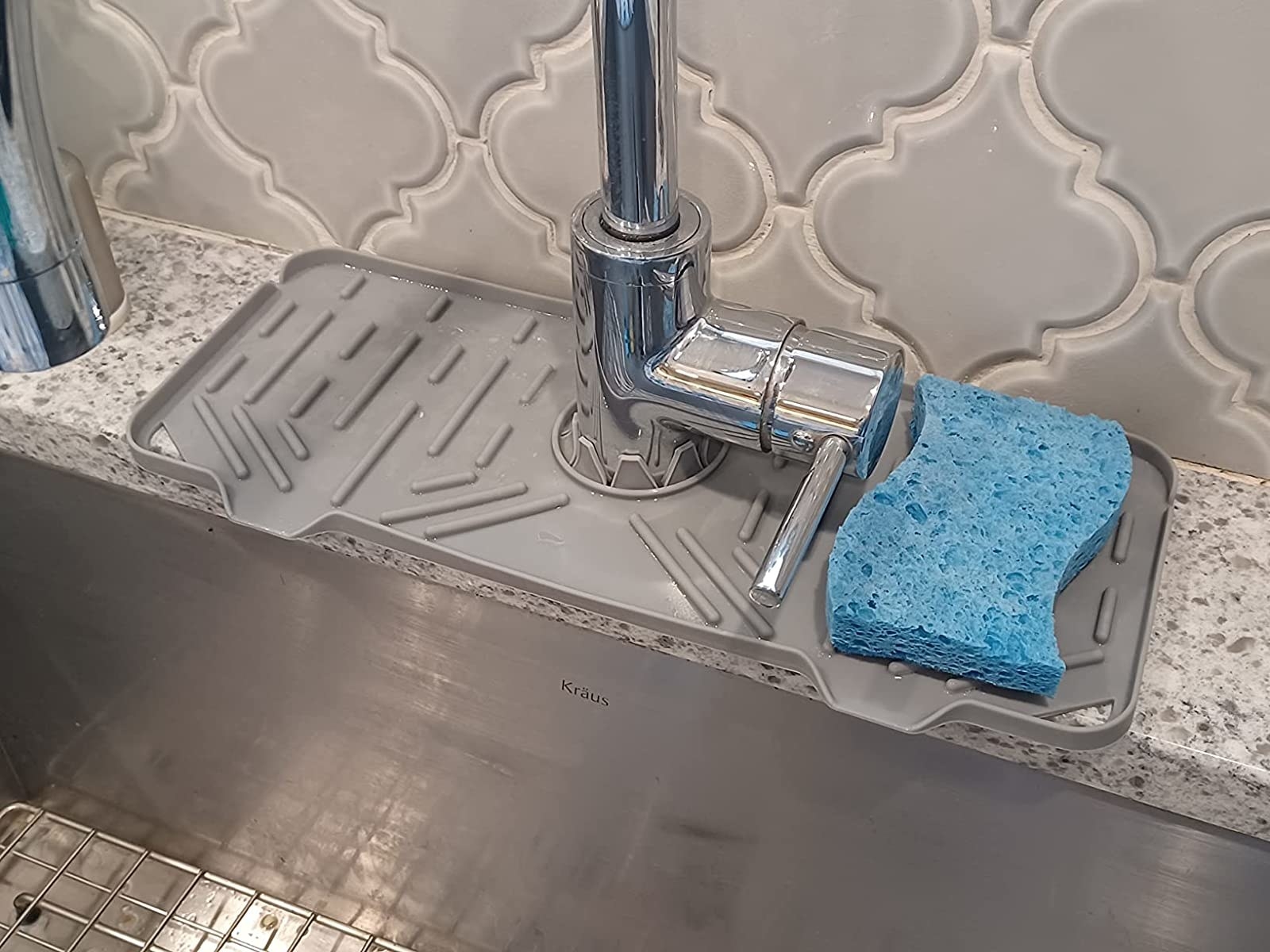 Reviewer image of the drip mat around their kitchen faucet