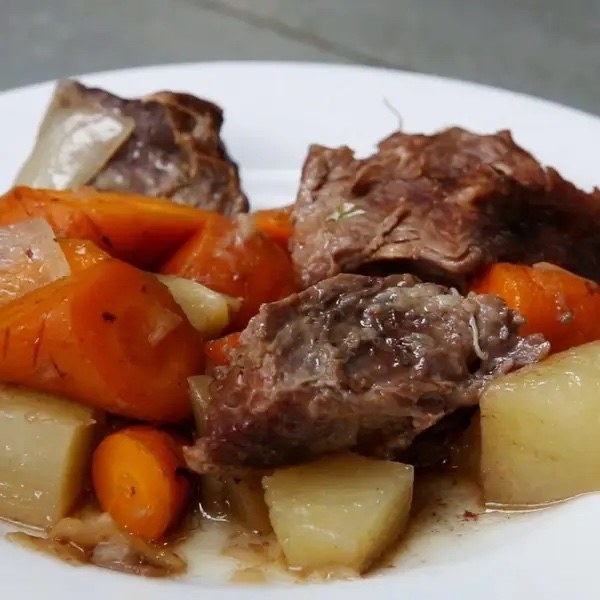 A plate of tender beef stew with carrots and potatoes, showcasing a hearty and savory dish