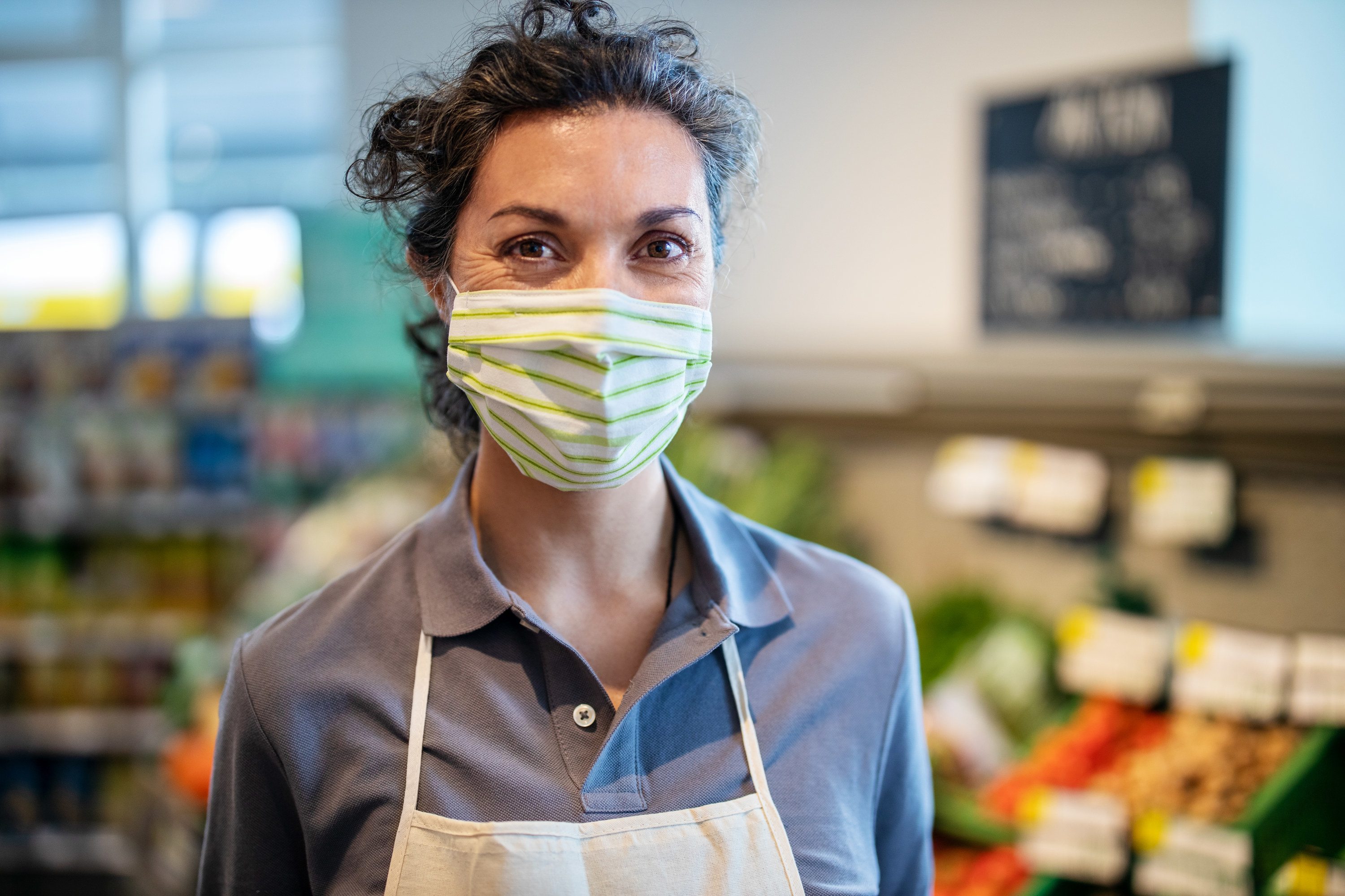 a grocery store worker with a mask on