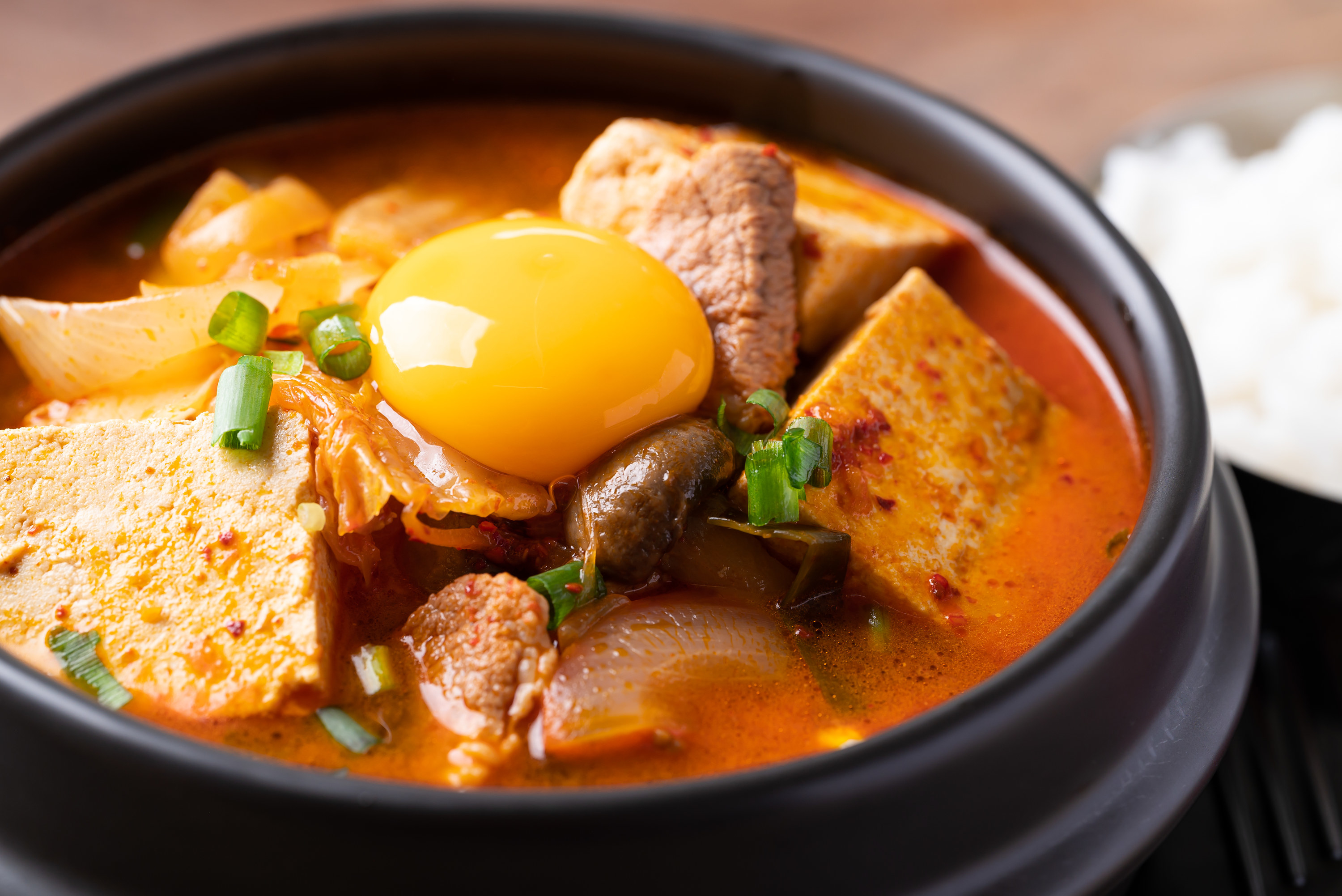 Close-up of kimchi stew with a cracked egg on top