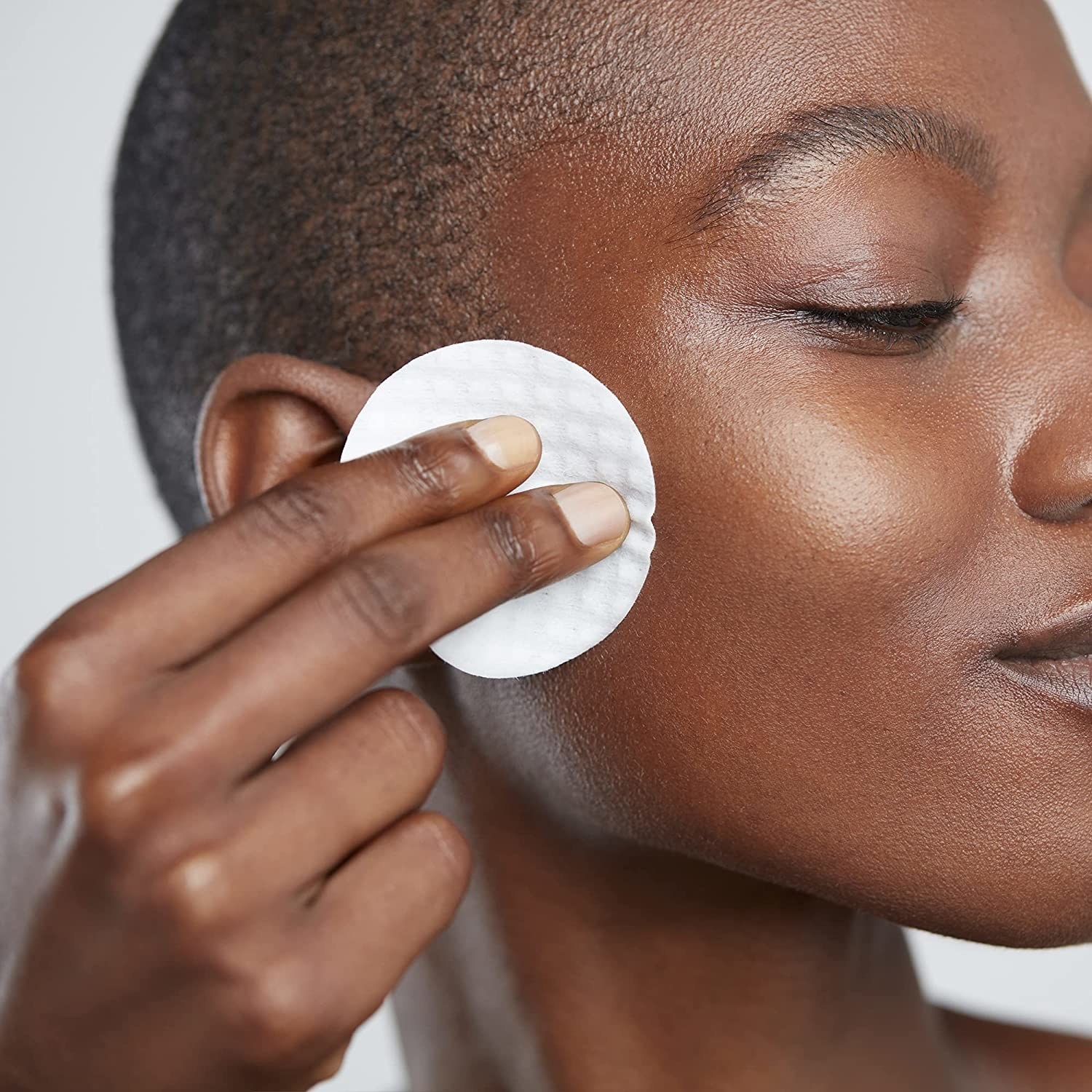 A model applying the pad to their skin