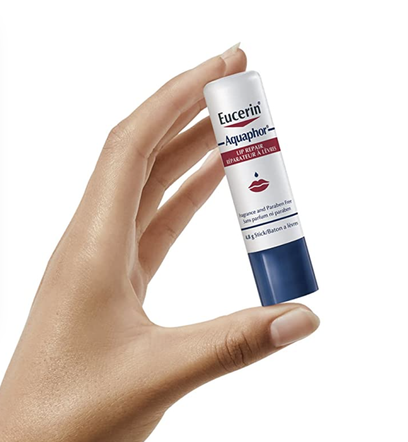a hand holding the lip balm against a plain background