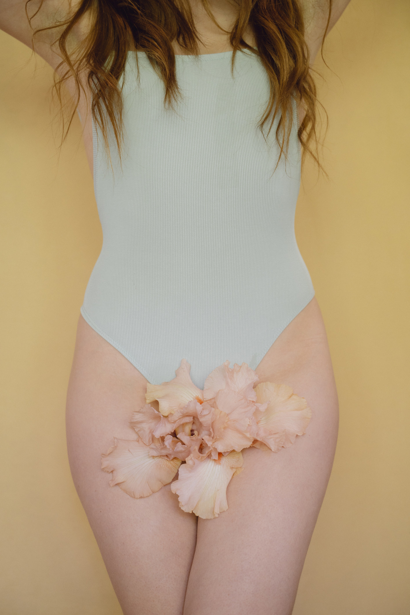 Young woman with pink flower wearing pastel blue swiming suit