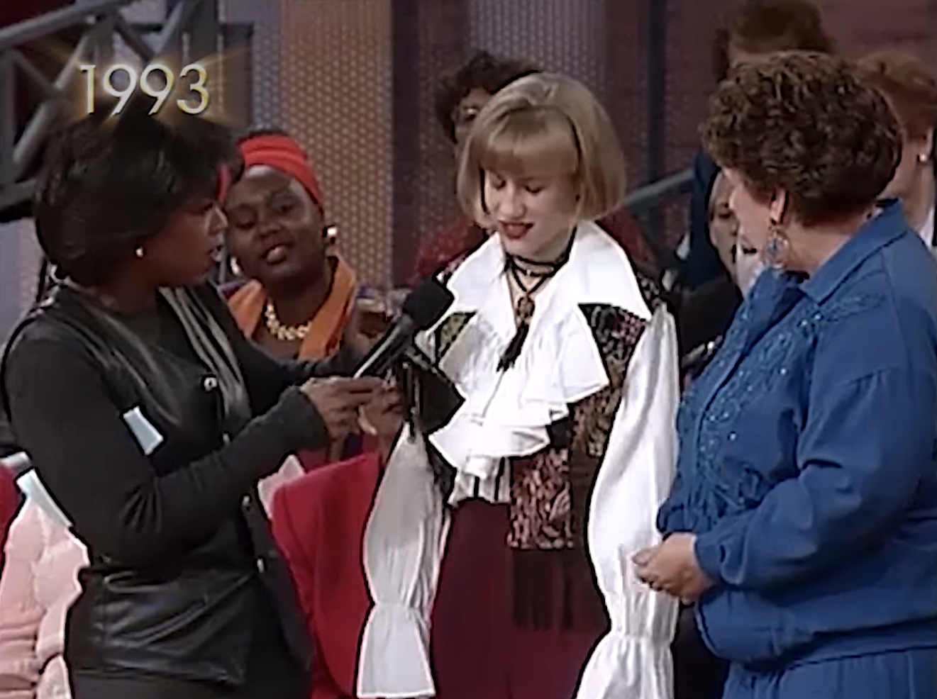 A young girl post-makeover talking to Oprah