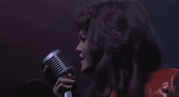 Diane Lane sings into a microphone
