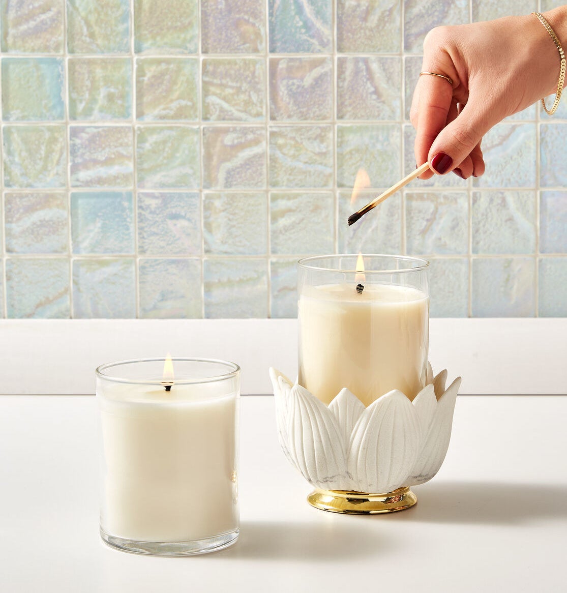 someone lighting a candle inside of the flower bowl holder