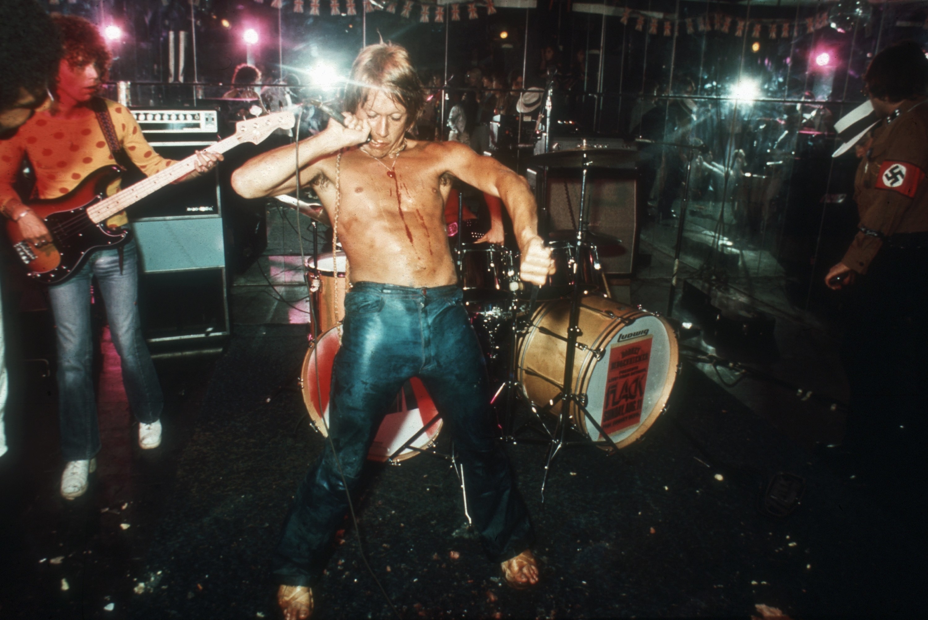 Iggy Pop in the middle of performing as his chest bleeds after cutting himself