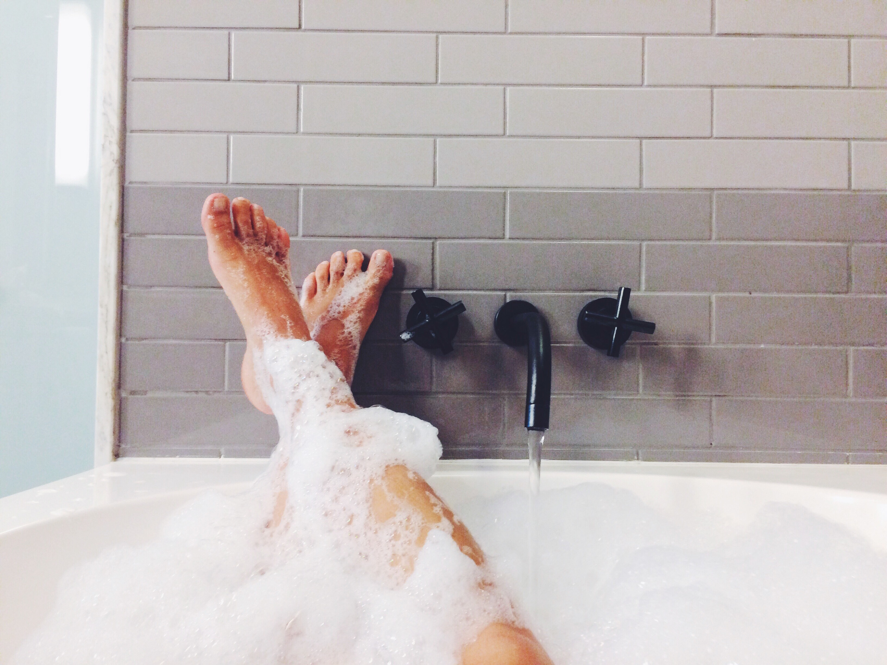 Someone&#x27;s legs in a bubble bath
