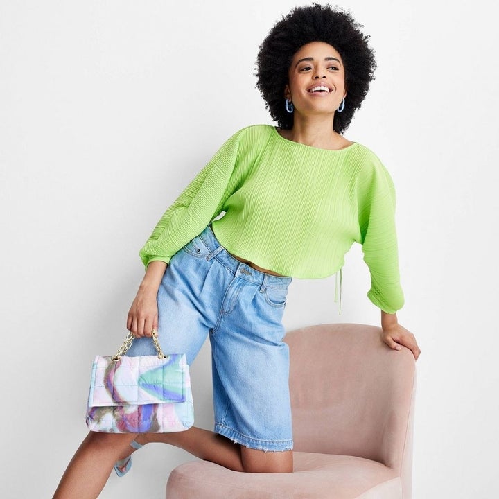 A model in lime green plisse top with croissant sleeves