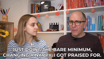 A man and a woman sitting next to each other talking about how he gets praised for doing the bare minimum