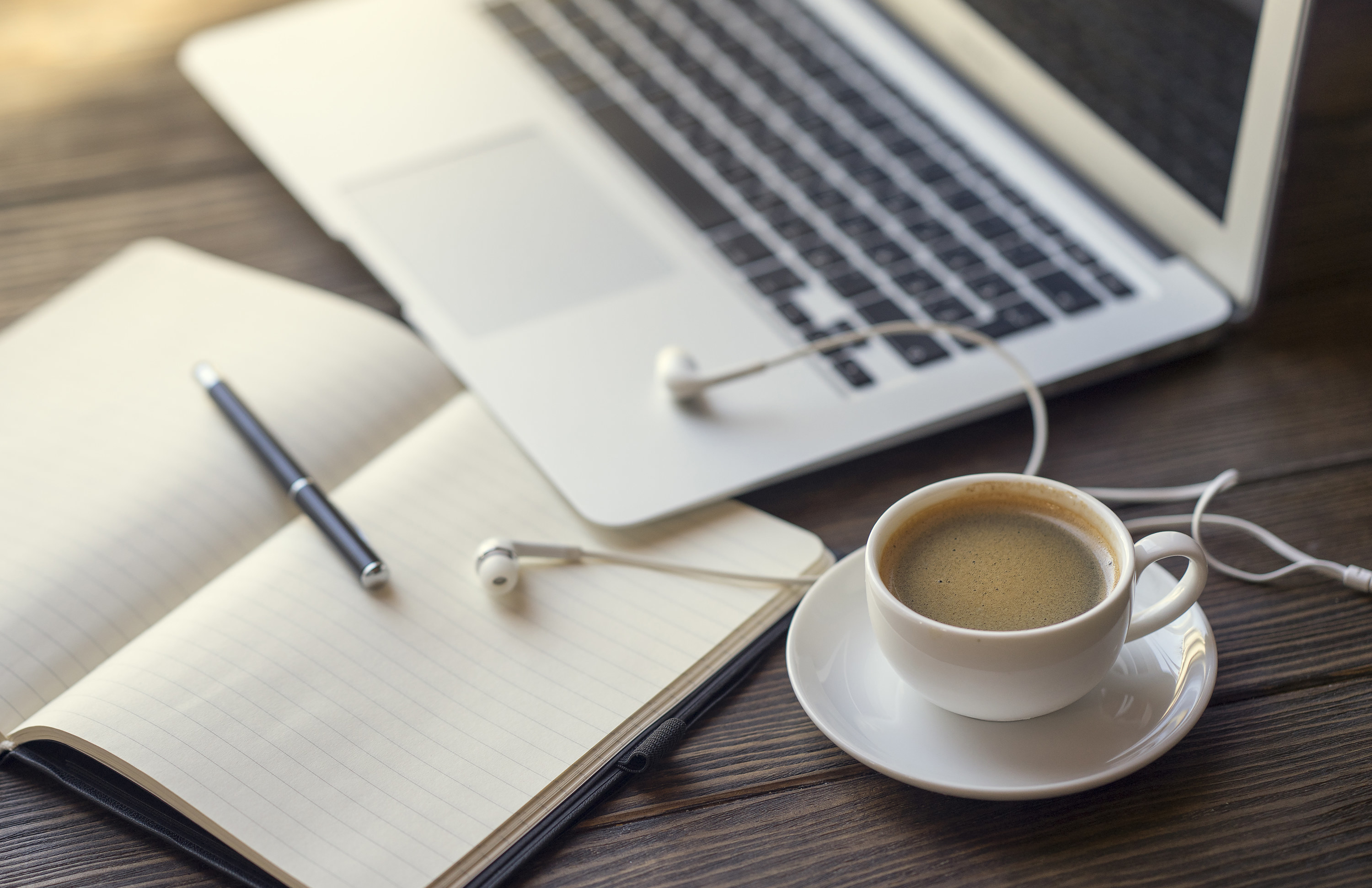 A coffee next to a laptop