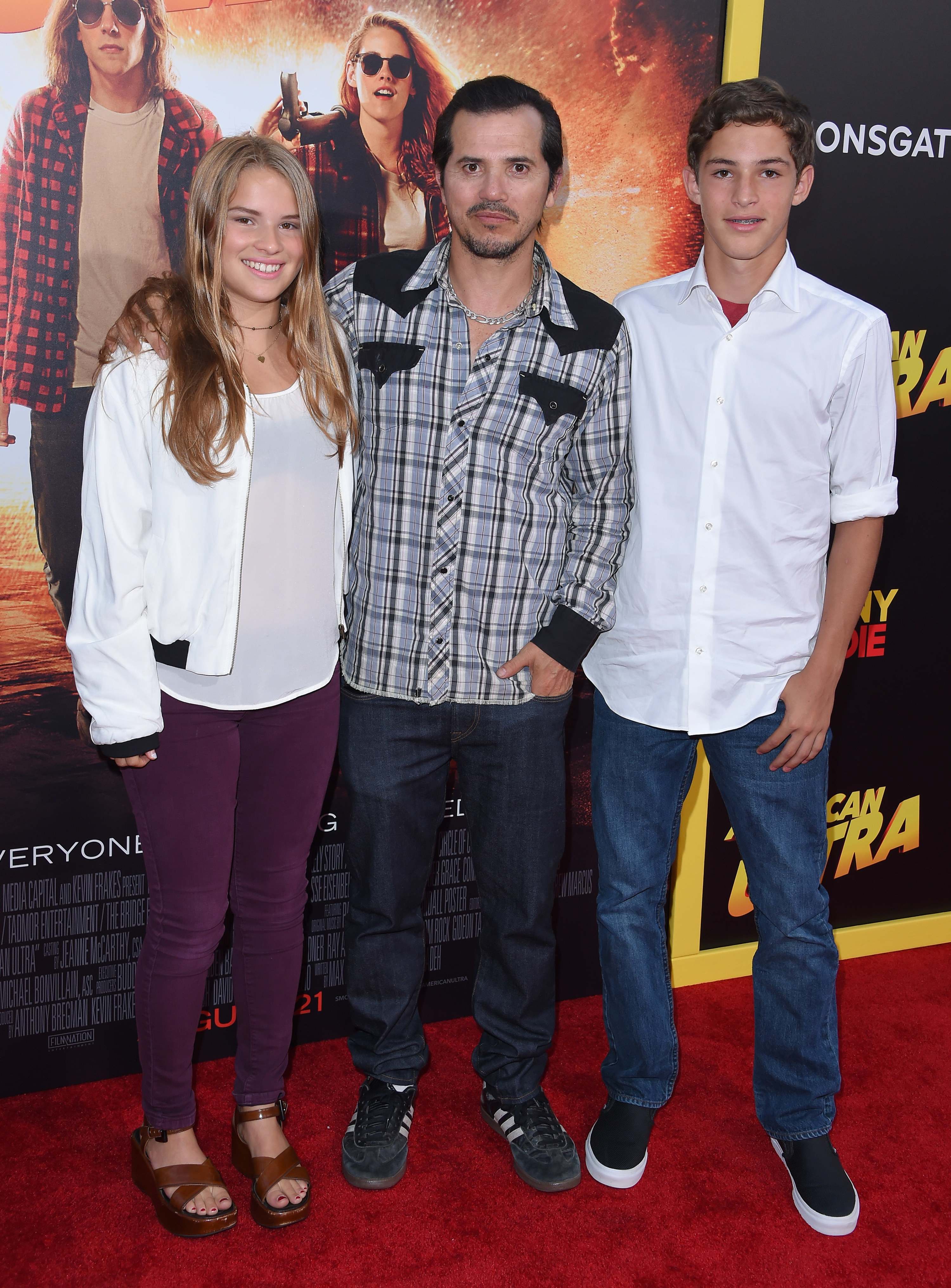 John Leguizamo posing on a red carpet with his son and daughter