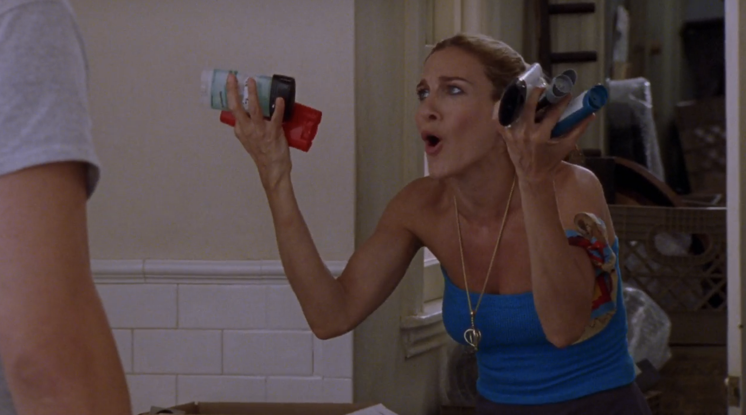 Carrie from Sex and the City holding up a man&#x27;s bathroom toiletries in frustration
