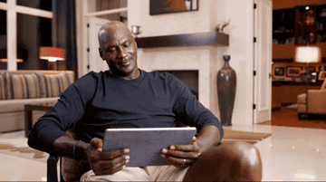 Michael Jordan laughing while on a tablet
