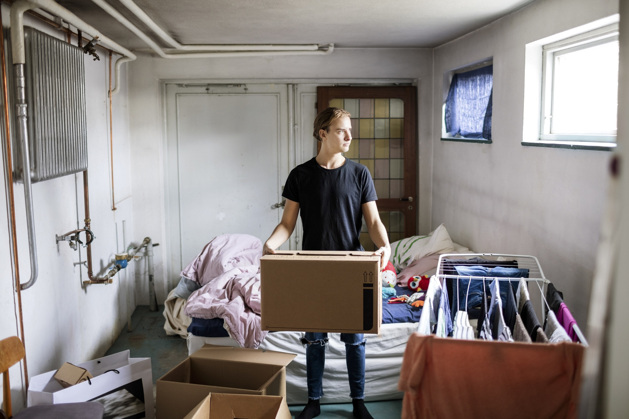 Man in basement holding cardboard box
