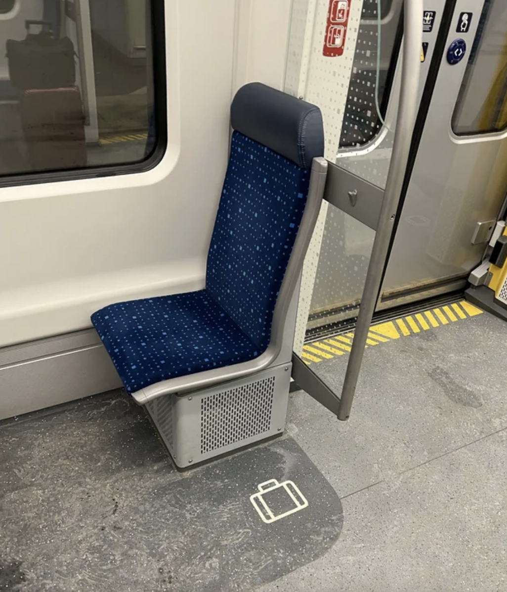 The floor next to a seat has a section in a different color with a suitcase icon on it