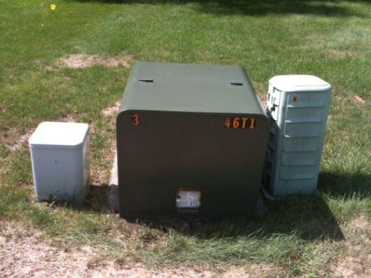 Three electrical boxes on a patch of grass