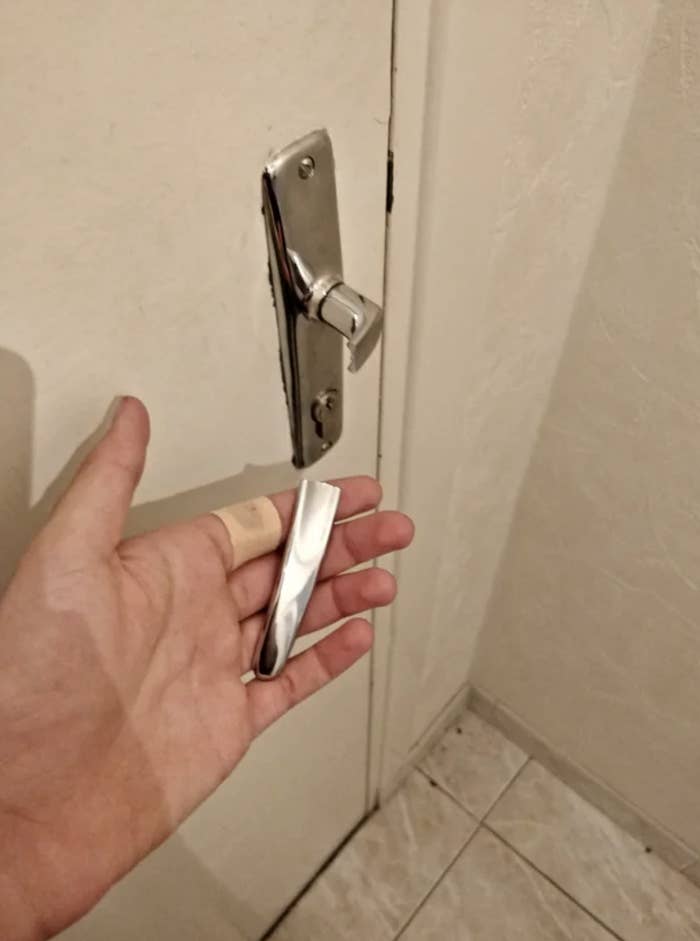 Someone holding a broken door handle