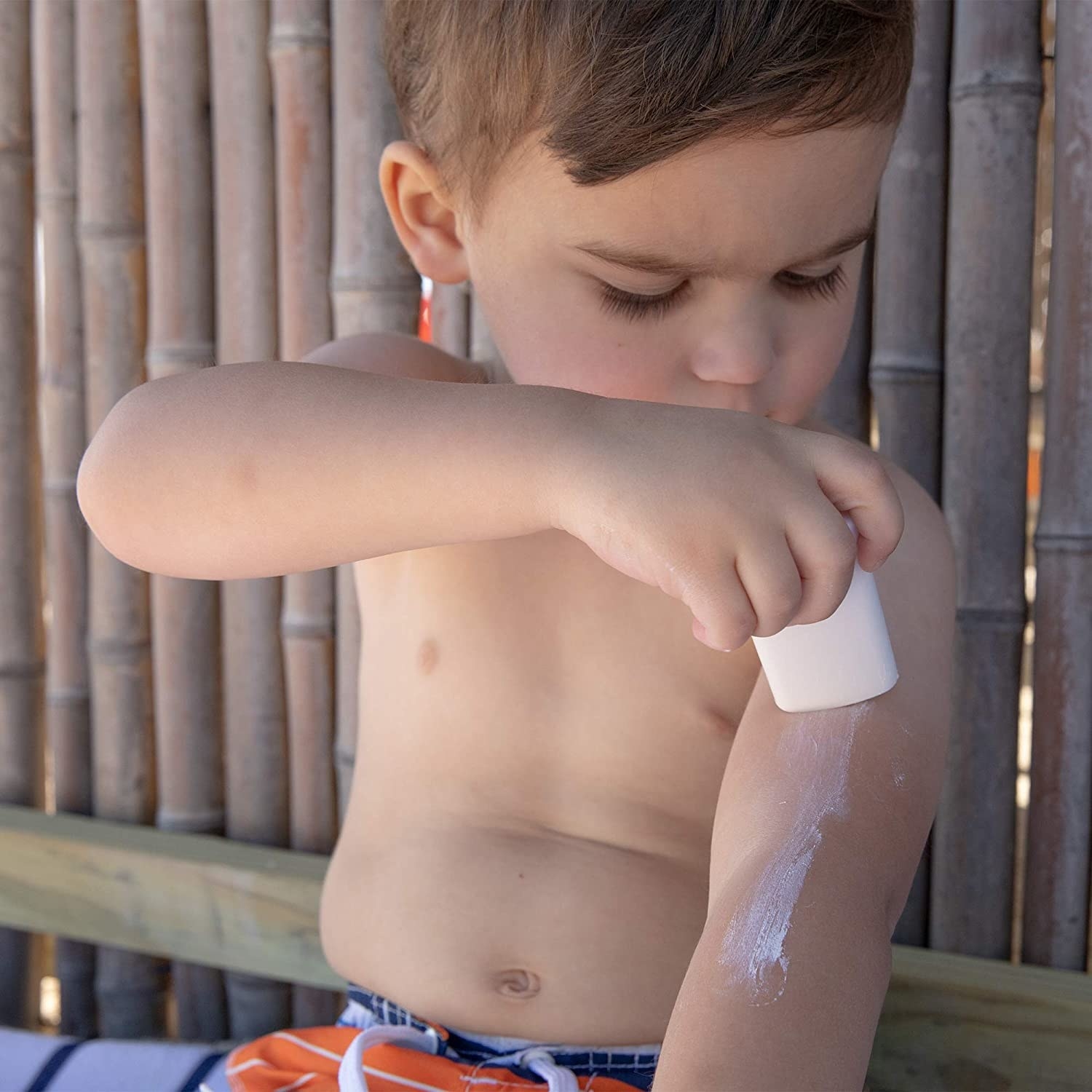 Kid applying sunscreen