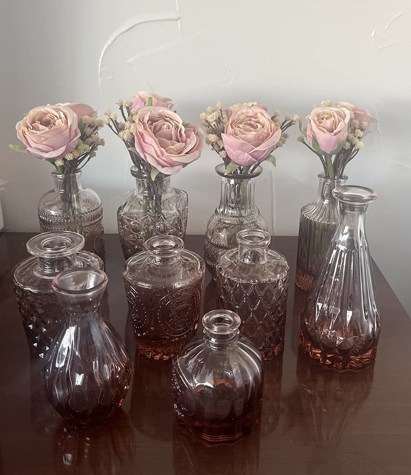 A reviewer&#x27;s photo of the pink vases with roses in them