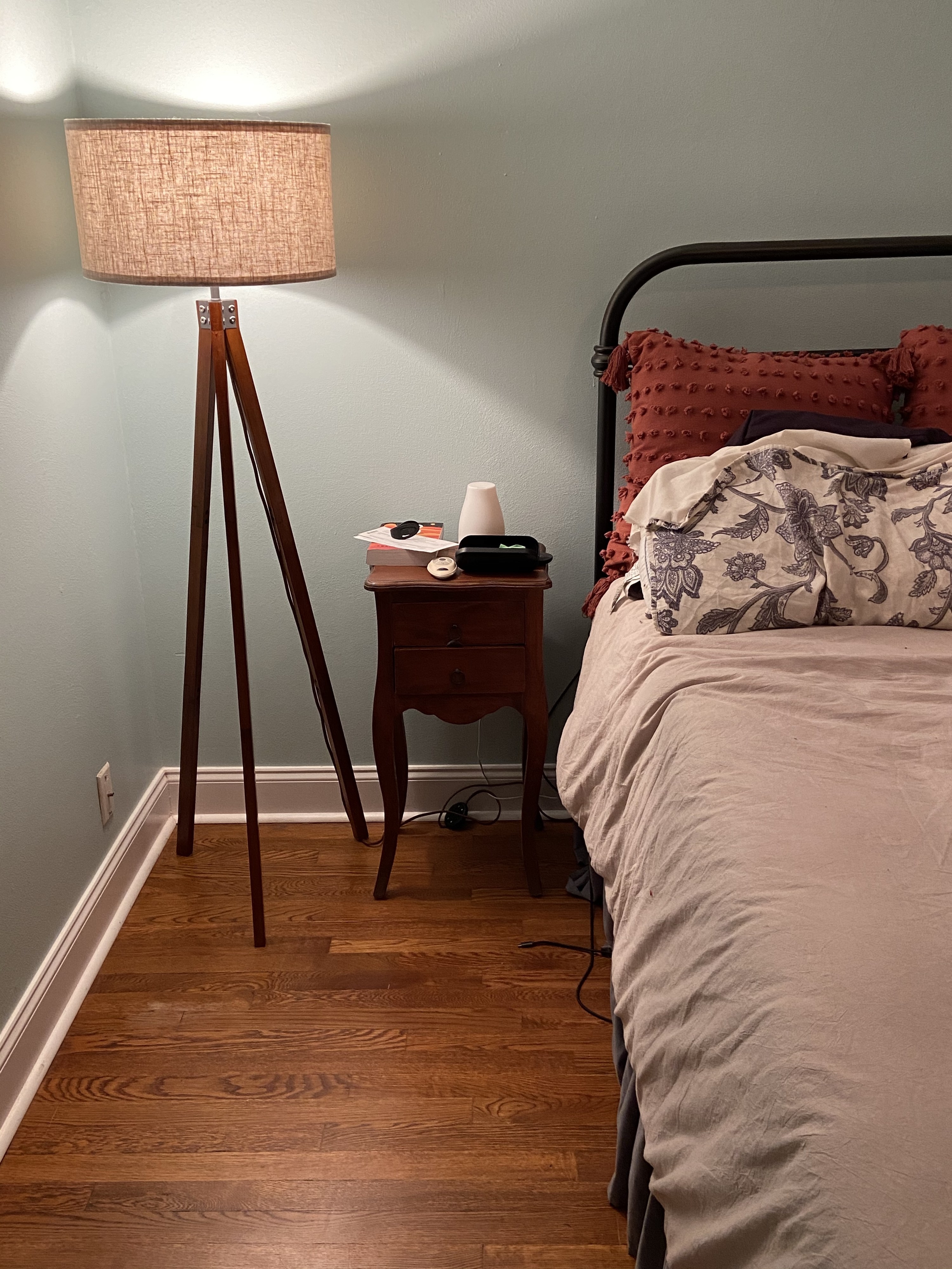 A reviewer photo of the lamp next to a bed