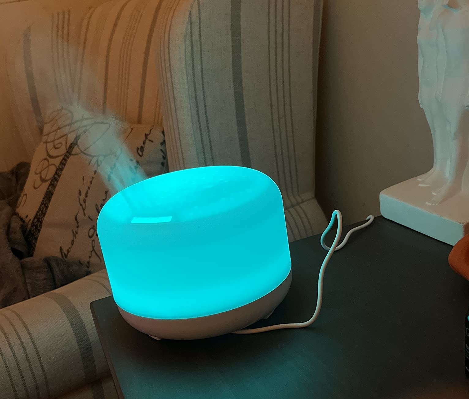 A reviewer&#x27;s photo of the oil diffuser with a blue light