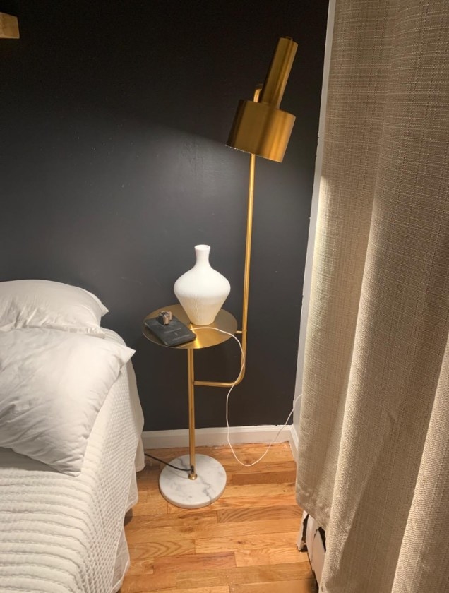 A reviewer&#x27;s photo of the floor lamp next to their bed