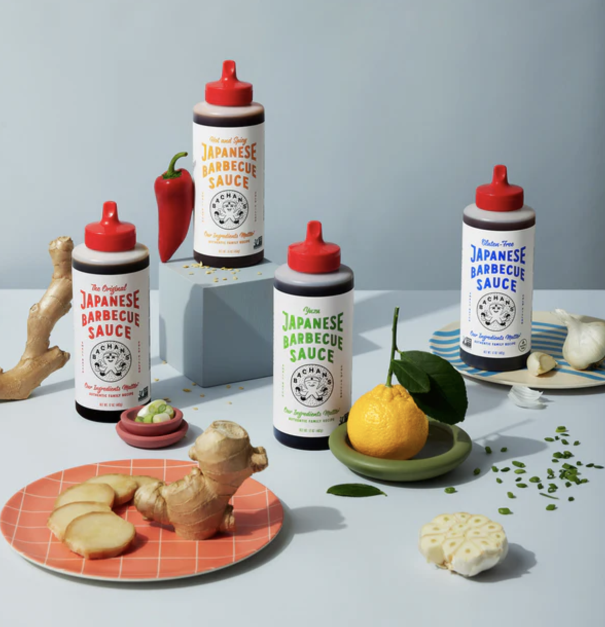 Four bottles of Bachan&#x27;s sauce surrounded by other cooking ingredients.