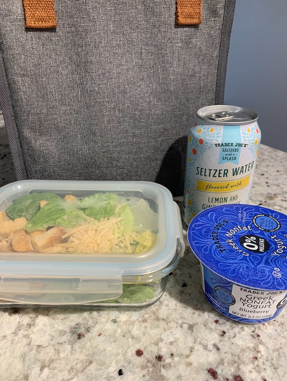 A salad, yogurt, and sparkling water