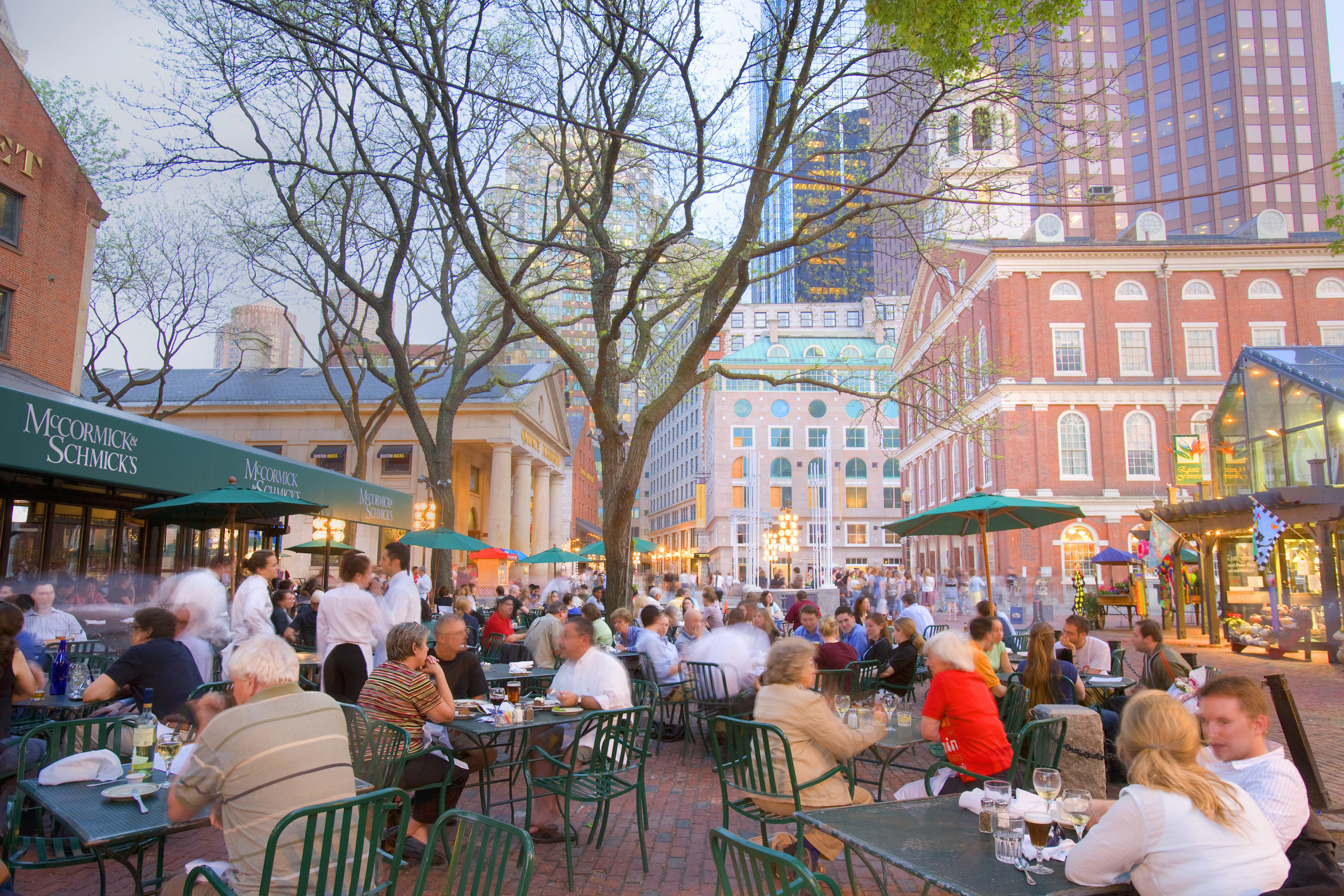 People dining at outdoor tables near Faneuil Hall.