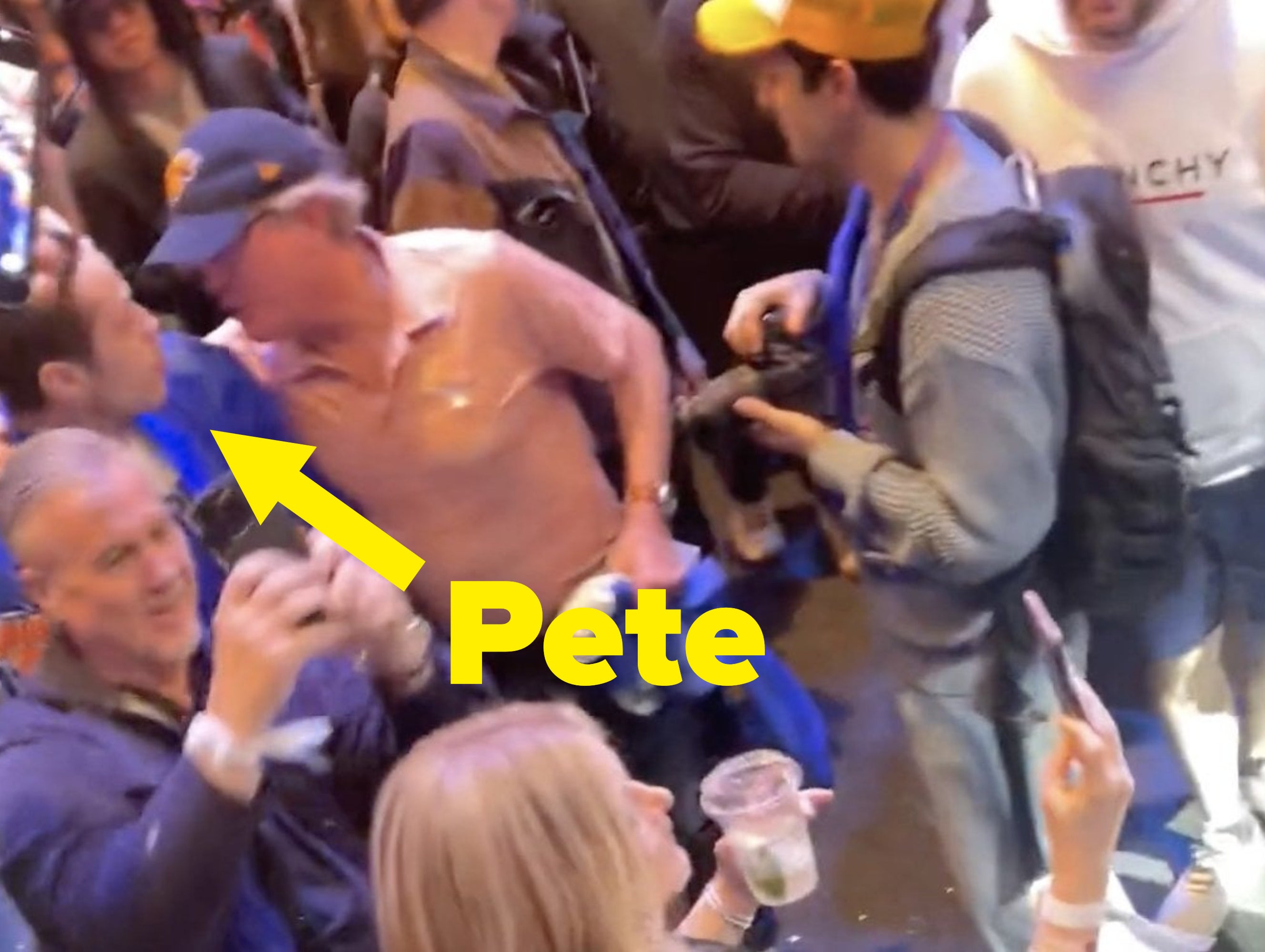 Pete is in a crowd and looking at a man leaning on