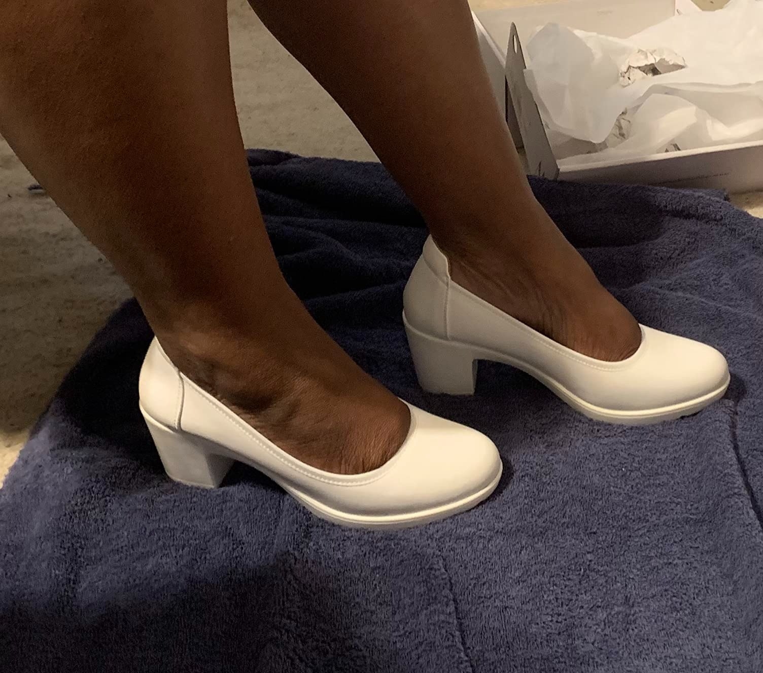 A reviewer wearing the white heels