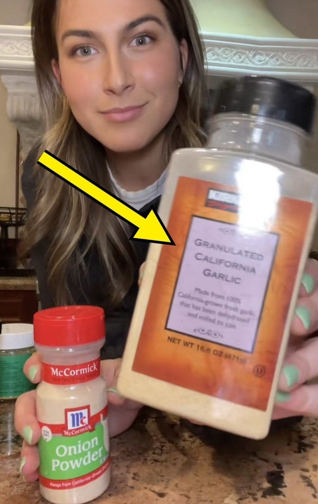 Zoe holding up a bottle of Costco&#x27;s Kirkland brand garlic powder to the camera, with an arrow pointing to it