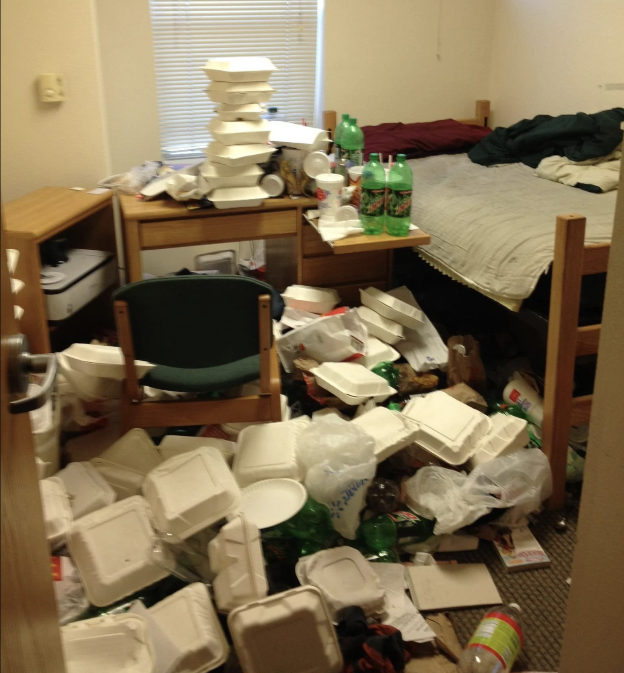 College dorm room filled with piles of to-go boxes and soda bottles