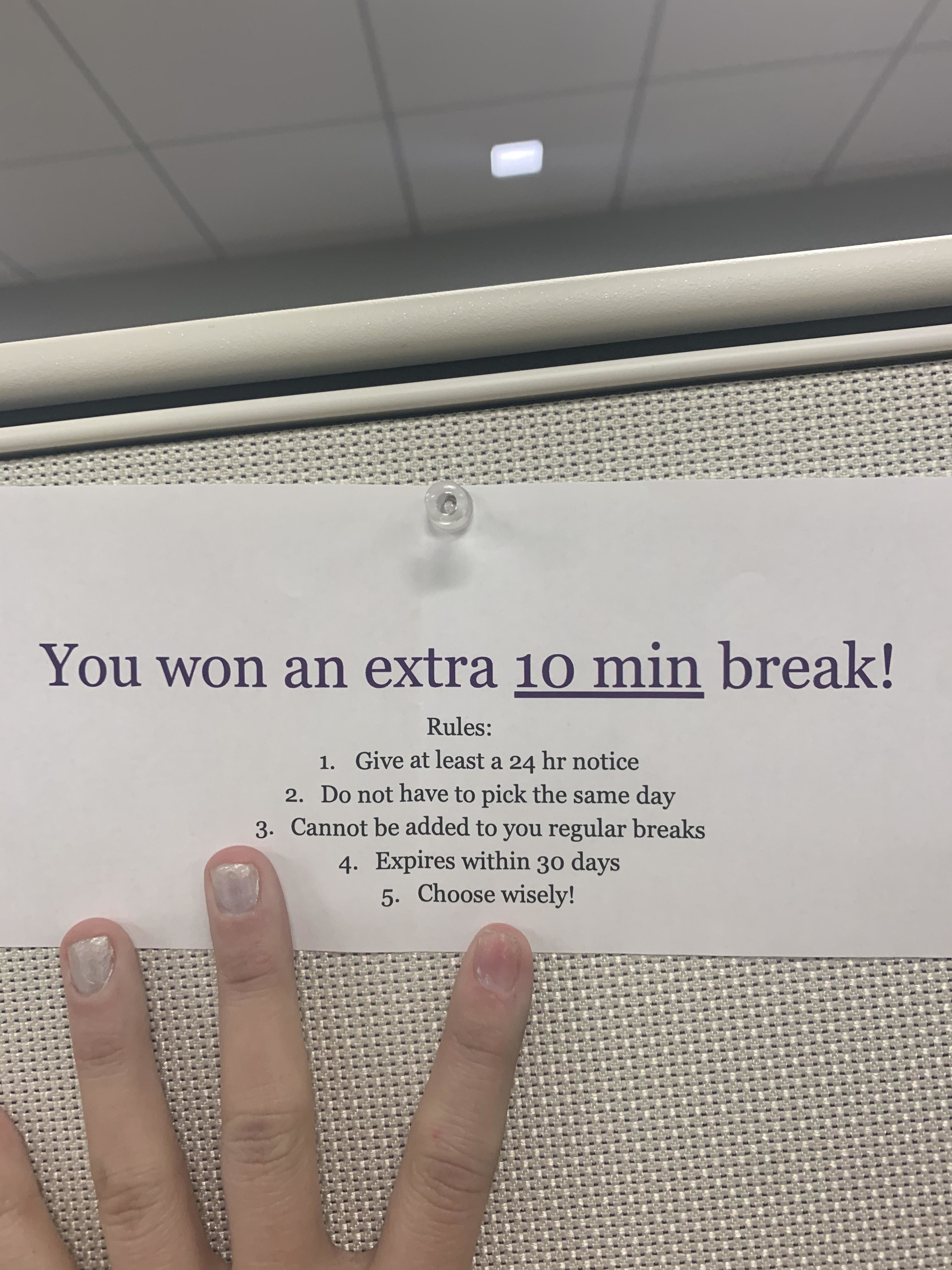 An employee holds a sign that reads &quot;You won an extra 10 min break&quot; followed by several rules