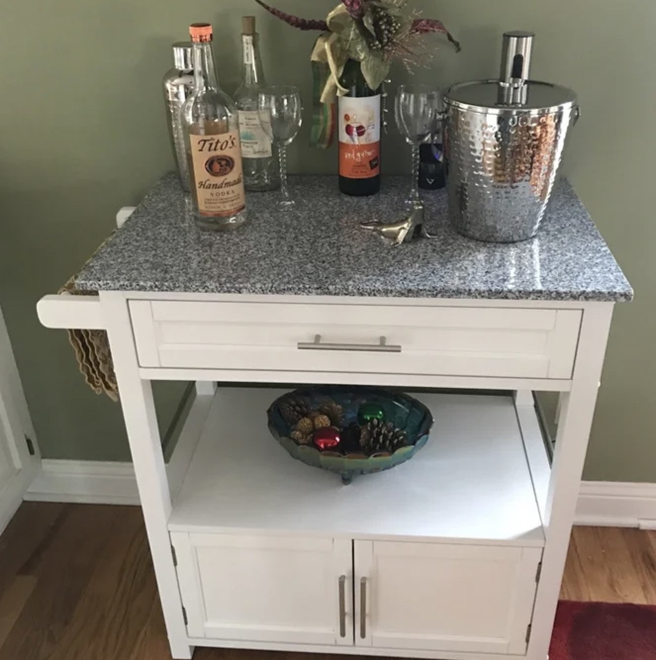 Reviewer&#x27;s grey granite top rollling kitchen cart with liquor and other bar essentials on top