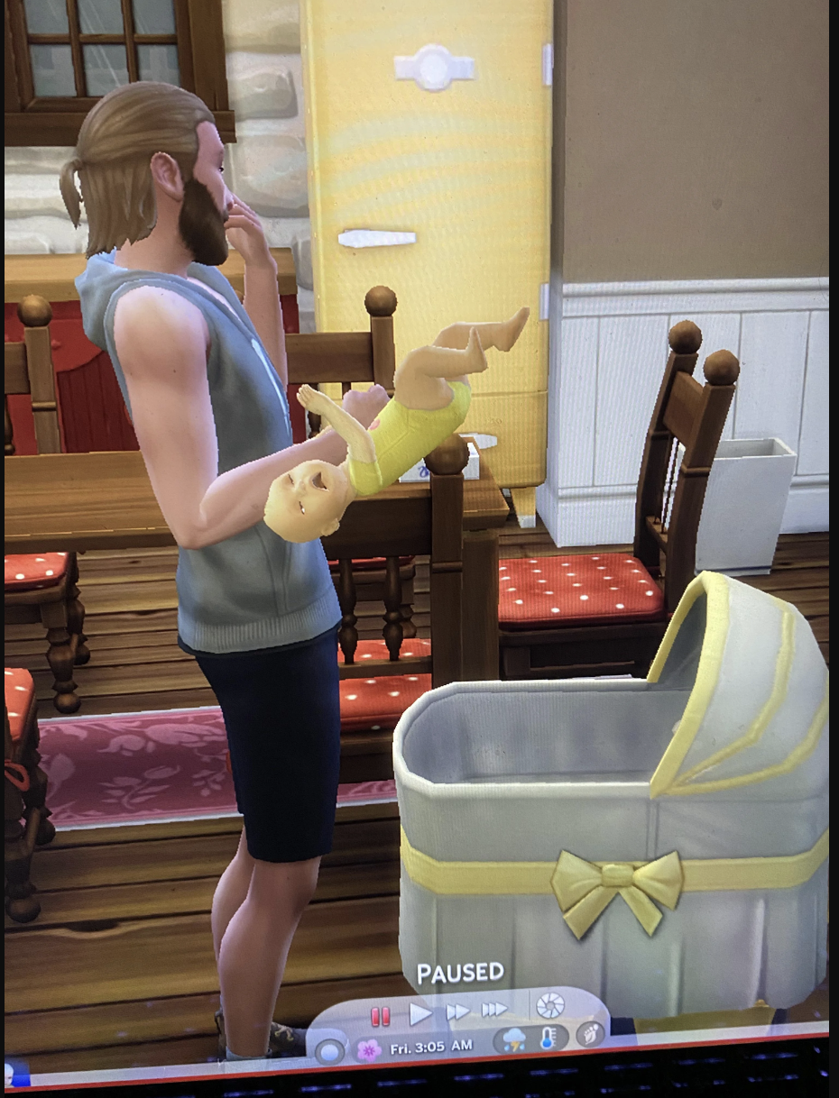 An adult Sim holding an infant Sim that's horizontally attached to the outside of his arm