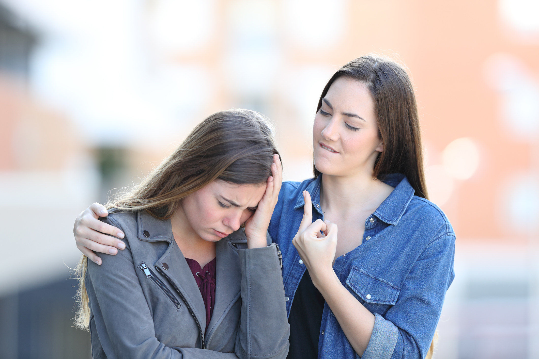Young woman giving the middle finger to another young woman