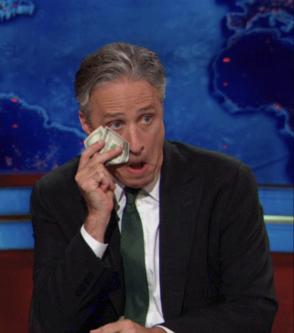 Jon Stewart wiping his face with money