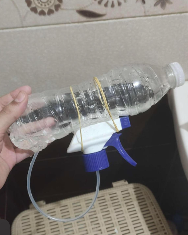 rubber bands holding a water bottle to a spray top