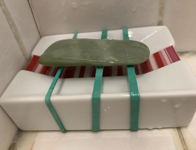 rubber bands over a soap dish with the soap bar left on top